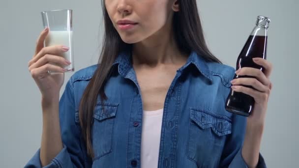 困惑的亚洲女人怀疑在甜饮料和牛奶之间 艰难的选择 — 图库视频影像