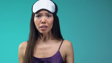 Duygusal Asya Bayan pijama ve eyemask gösteren saat, iş closeup için geç