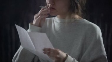 Mektup okuma ve zarfı, sigorta koyarak sigara olan kadın