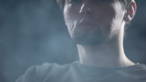 Młody Mężczyzna Siedzący Pomieszczeniu Pełnym Dymu Świadomość Wpływu Nikotyny Koncepcja — Wideo stockowe