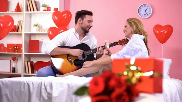 Mann Spielt Gitarre Und Singt Der Verführerischen Dame Champagner Bett — Stockfoto