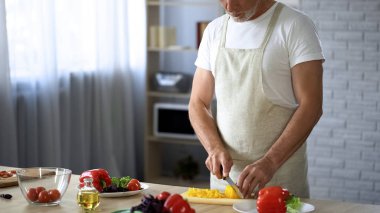 Pişirme ipuçları, eğlence hobi önlük kesme taze salata mutfakta yaşlı erkekte