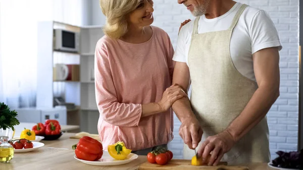 Fürsorglicher Ehemann Schürze Schneidet Frischen Pfeffer Für Salat Aussehende Frau — Stockfoto