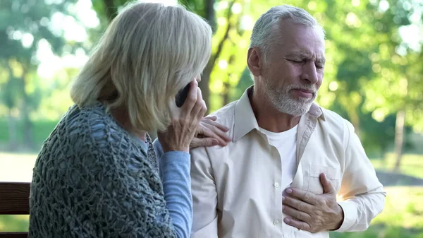 Woman Calling Emergency Service Pensioner Suffering Heart Attack Park — Stock Photo, Image