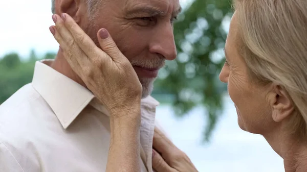 退休妇女触摸男人的脸 浪漫的约会在公园里 爷爷奶奶爱 — 图库照片