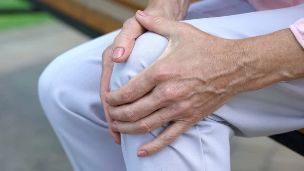 Γριά Αγγίζοντας Γόνατο Κάθεται Στο Παγκάκι Πόνος Στις Αρθρώσεις Προβλήματα — Φωτογραφία Αρχείου