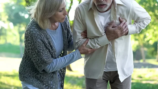 老人医療 心臓発作の妻と散歩中に心の痛みを持っていること — ストック写真