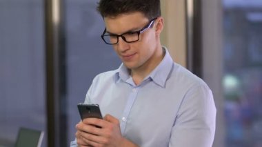 Gülümseyen iş adamı kaydırma smartphone, okuma mesaj, mobil iletişim