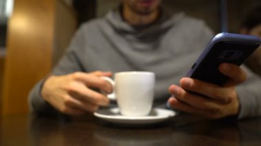 Kahve zevk ve mobil uygulamaları kullanarak genç adam serbest zaman yalnız, yakın