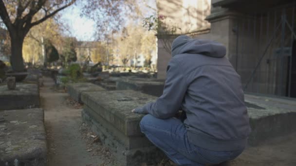 Smutny Człowiek Modli Się Pobliżu Grobu Stary Cmentarz Upamiętniający Rodziny — Wideo stockowe