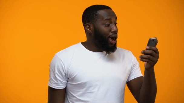 Opgewonden Zwarte Mannelijke Bedrijf Boodschappentas Smartphone Geld Terug Diensten — Stockvideo