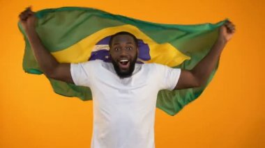 Afrikalı-Amerikalı adam Brezilya bayrağı sallayarak ulusal spor takımı destekleyen