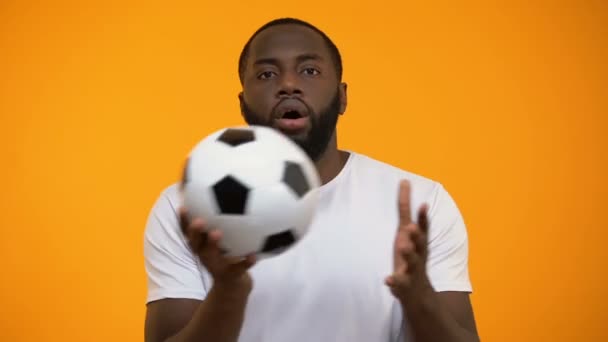 Homem Afro Americano Com Bola Futebol Assistindo Jogo Mostrando Rosto — Vídeo de Stock