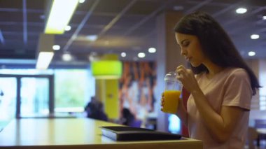 Taze portakal suyu içme plastik cam ve gülümseyerek, diyet esmer kadın