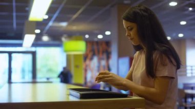 Genç Bayan oturma Cafe tablo, abur cubur bağımlılığı, sağlıksız yemek hamburger yemek