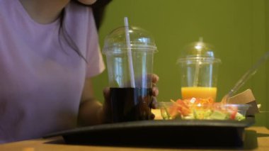 Genç kadın meşrubat saman, öğrenci kafede öğle yemeği tatma