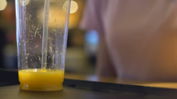 柑橘系カクテル ストローでオレンジ ジュースを飲んでのどが渇いてカフェ顧客 — ストック動画