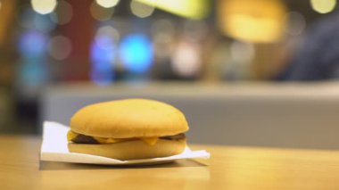 Burger Cafe tablodan alarak ve ısırıldı sandviç geri koyarak el