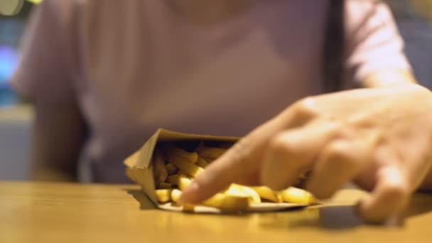 年轻女性在快餐店吃香脆的炸薯条 不健康的零食 — 图库视频影像