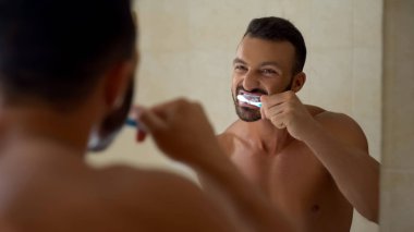 Sakallı adam dikkatle fırçalarken, sabah yordamı, diş bakımı beyazlatma