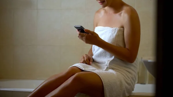 女性阅读信息从男友在浴室 使用电话 — 图库照片