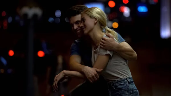 幸福的年轻夫妇在爱说话和拥抱在城市街道上晚上 — 图库照片