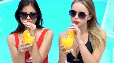 Gülme, kutlama ve kokteyller havuz içme güzel kadınlar