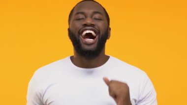 Dans ve having fun Sarı zemin üzerinde mutlu bir Afrikalı-Amerikalı adam yakın çekim