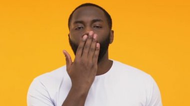 Flört ve hava öpücük kamera, sarı arka plana gönderme Afrikalı-Amerikalı adam