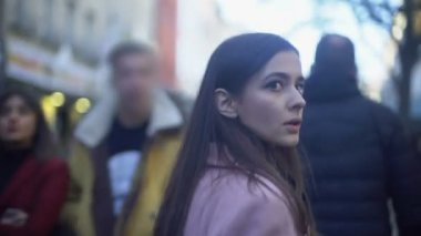 Gergin genç kadın suç kalabalık caddede yürüyüş ve etrafında dönen