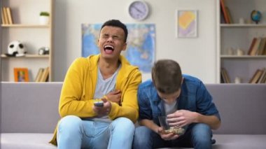 Afrikalı-Amerikalı ve Beyaz arkadaşlar Komedi patlamış mısır yemek televizyonda göstermek izlemek