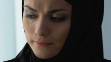 Hijab ayakta yakınındaki pencere, duygu zarar kocakesinlikle aldatıyor, üzgün Müslüman kadın