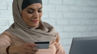 Alışveriş online memnun Müslüman Bayan dizüstü pc üzerinde kredi kartı numarası ekleme