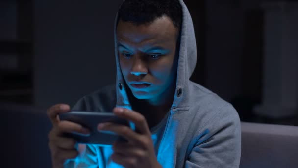 スマート フォンでビデオ ゲームを勝利 過剰反応の非常に感情的な黒人の男 — ストック動画