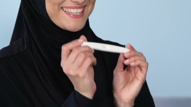 肯定的な妊娠検査 友人のお祝いを持って幸せなイスラム教徒の女性 — ストック動画