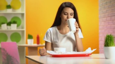 Güzel kadın kantin, abur cubur overeating, aperatif Kağıt bardakta içme