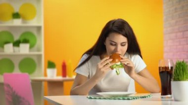 Tatsız burger tabağında, ucuz gıda kalitesi koyarak üzgün kadın müşteri