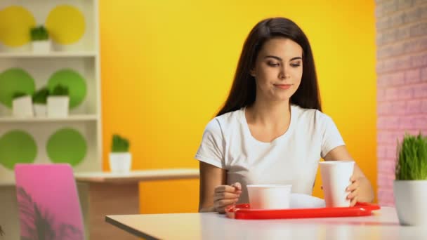 若い女性使い捨てガラスから飲むとカフェの食事の後に口を拭く — ストック動画