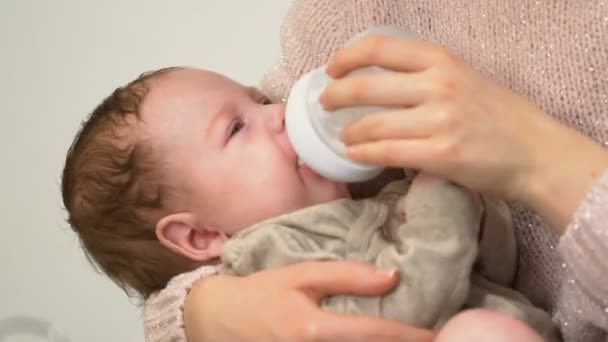 年轻的保姆给可爱的婴儿牛奶从瓶子 抗肿瘤配方奶粉 — 图库视频影像