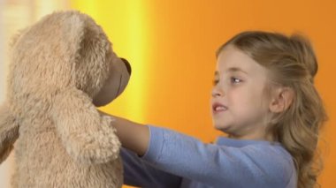 Oyuncak ayı seyir ve en sevdiği oyuncak, sarılma sevimli okul öncesi kız çocuk