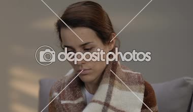 Depresif genç kadın kanepede oturuyordu ekose, terminal hastalık ile kaplı