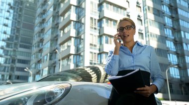 Businesslady ortakla sözleşme koşullarını tartışırken, telefonla iletişim kurar