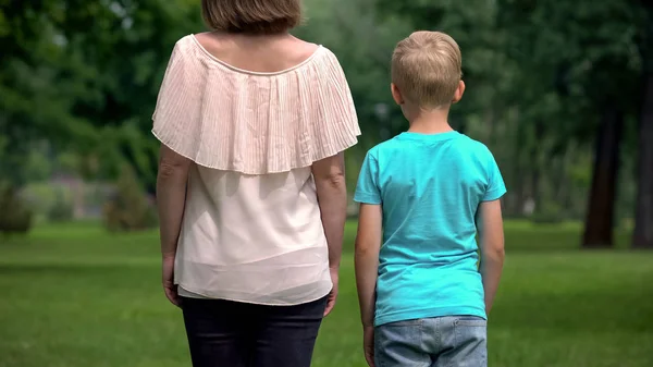 女性と少年 手をつないで一緒に歩く距離社会的保護の概念 — ストック写真