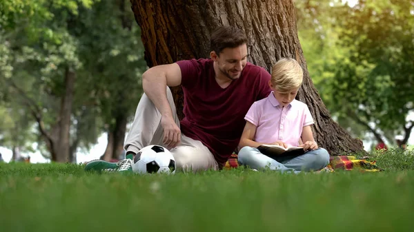 Papá Hijo Leyendo Libro Sentado Parque Bajo Árbol Hobby Juntos —  Fotos de Stock