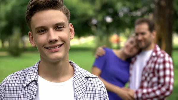 Netter Junge Lächelt Vor Dem Hintergrund Fröhlich Umarmender Eltern Unterstützt — Stockfoto