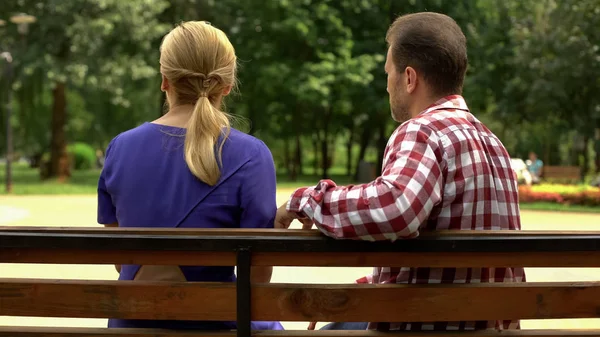 Indifferent man and woman sitting on bench, no common interests, break up