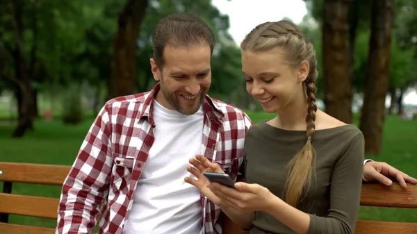 Bonito Adolescente Filha Mostrando Vídeo Engraçado Celular Para Pai Relaxar — Fotografia de Stock