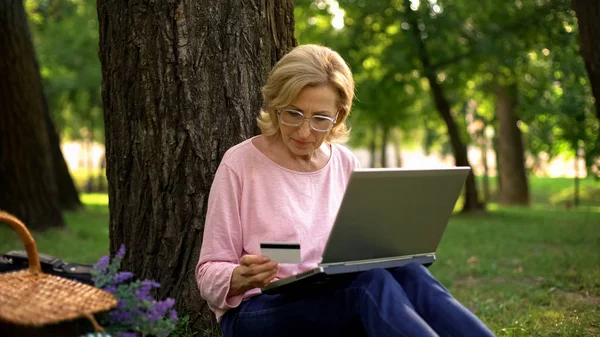 Gutaussehende Rentnerin Sitzt Mit Laptop Park Und Kauft Online Ein — Stockfoto