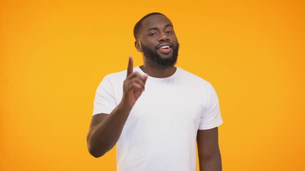 Sorrindo Homem Negro Apontando Dedo Piscando Conscientemente Contra Fundo Amarelo — Vídeo de Stock