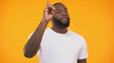 Parmak kamera işaret ve sarı arka planı gülümseyen adam genç siyah